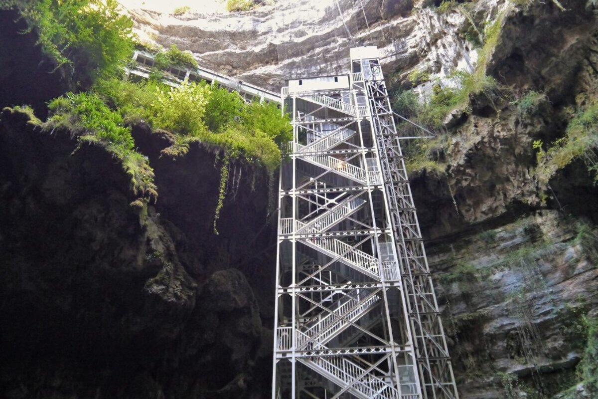 a set of metal steps with a cavern of gouffre de padirac