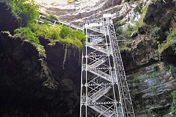 a set of metal steps with a cavern of gouffre de padirac