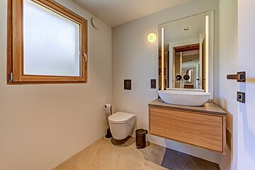 A bathroom with a toilet a sink and a window
