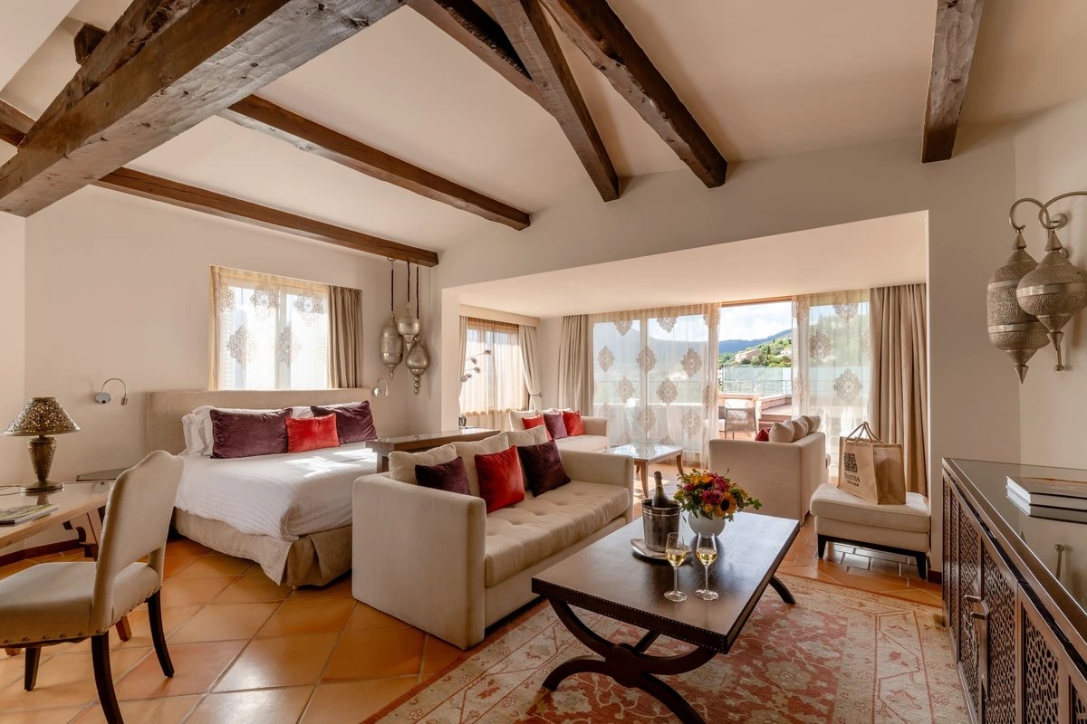 A hotel room with a couch and a bottle of wine