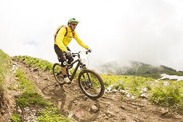 a mountain biker in a yellow jacket