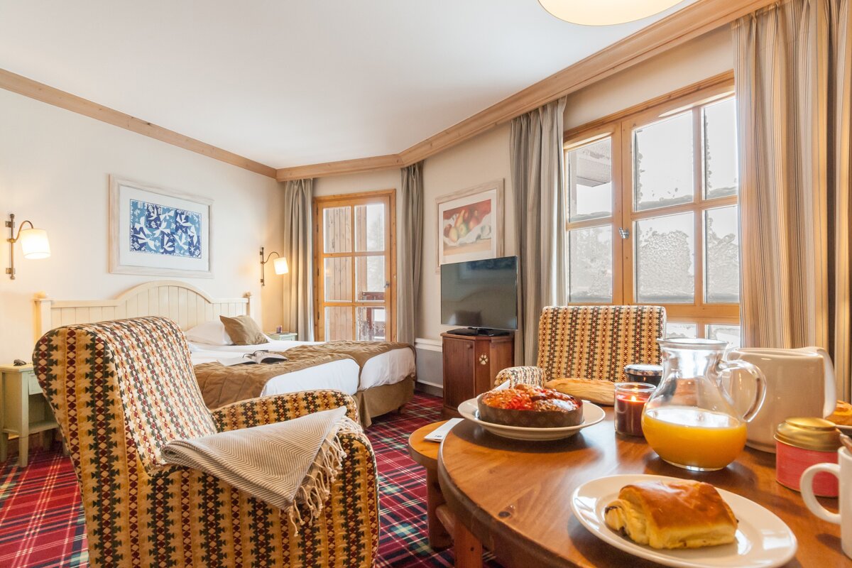 A hotel room with two beds and a table with a plate of food on it