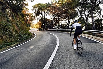 A person is riding a bike down a curvy road