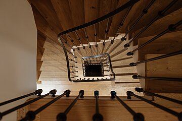 Looking down a spiral staircase with a black railing