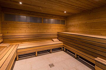 A wooden sauna with a drain in the floor