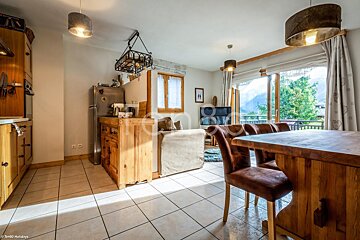 A living room with a table and chairs and a refrigerator