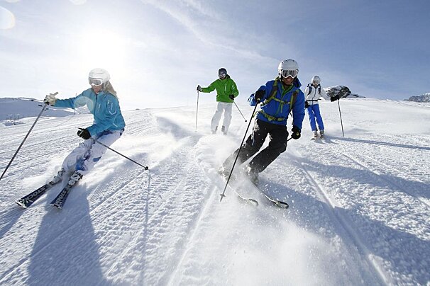 A group of people skiing down a snow covered slope