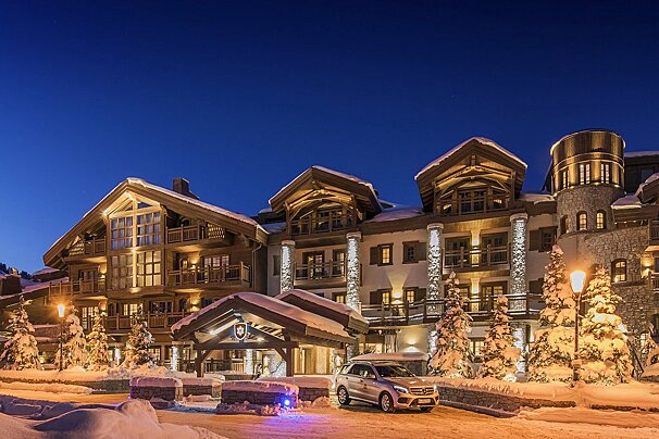A car is parked in front of a snow covered building