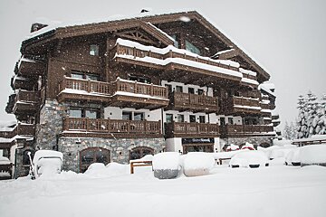 A snowy building with a sign that says savoy hotel
