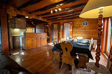 A wooden dining room with a table and chairs and a lamp