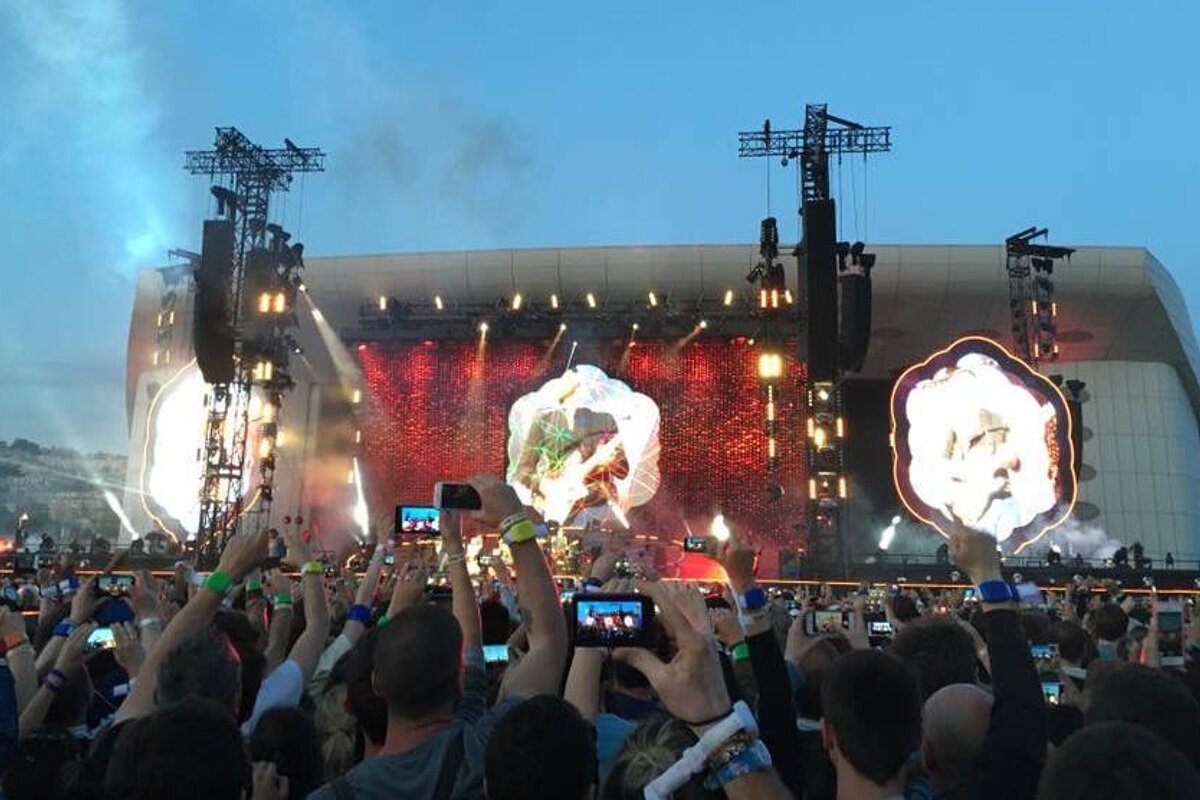 A crowd of people taking pictures of a concert with their phones