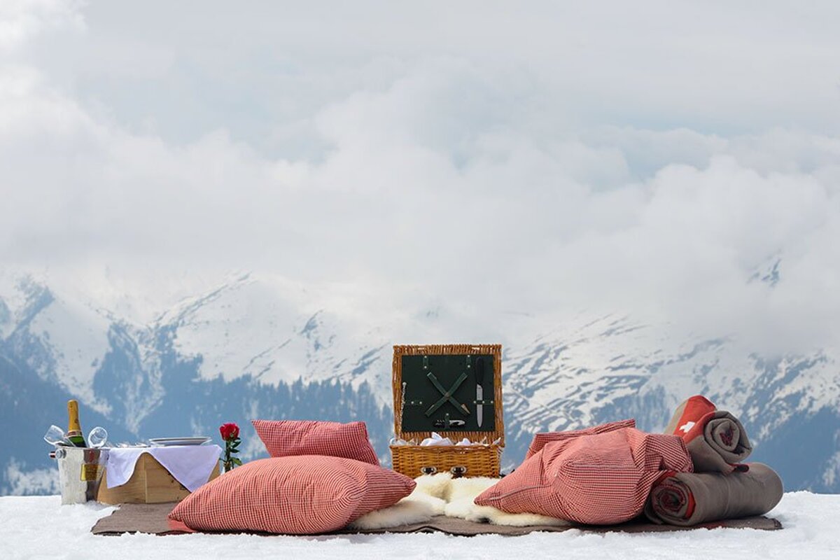 A picnic set up in the snow with mountains in the background