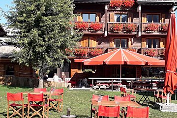 A large red umbrella sits in front of a restaurant