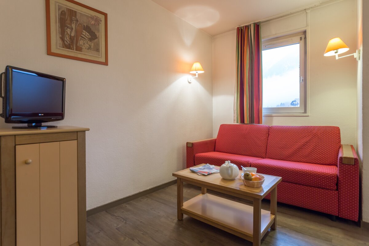 A living room with a red couch and a flat screen tv