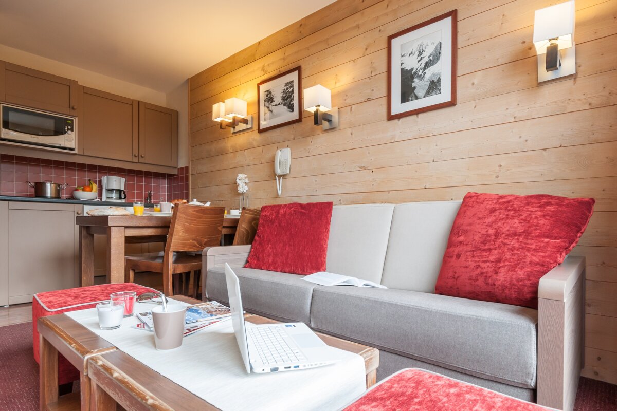 A living room with a couch and a laptop on the table