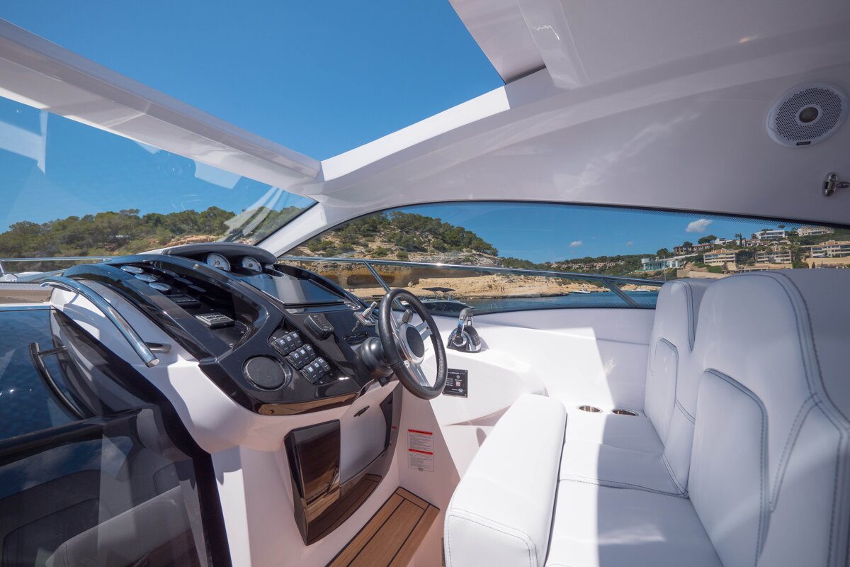 The inside of a boat with a steering wheel and dashboard