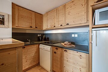 A kitchen with wooden cabinets and a white dishwasher