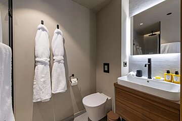 A bathroom with a toilet a sink and a mirror