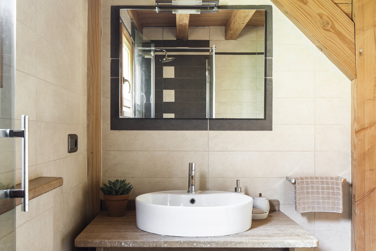A bathroom with a sink and a mirror above it
