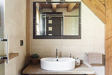 A bathroom with a sink and a mirror above it