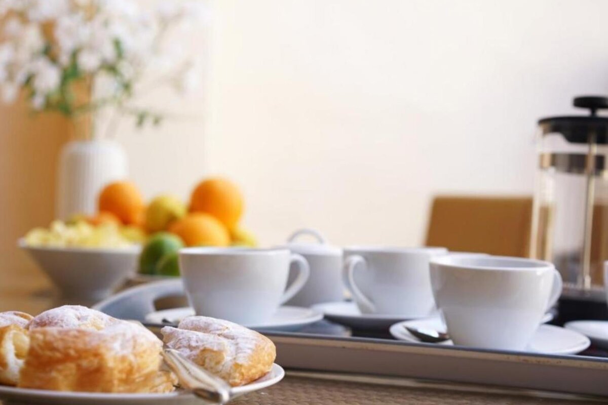 A tray of coffee cups and pastries on a table