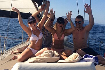 A group of people on a boat with one wearing a ny hat