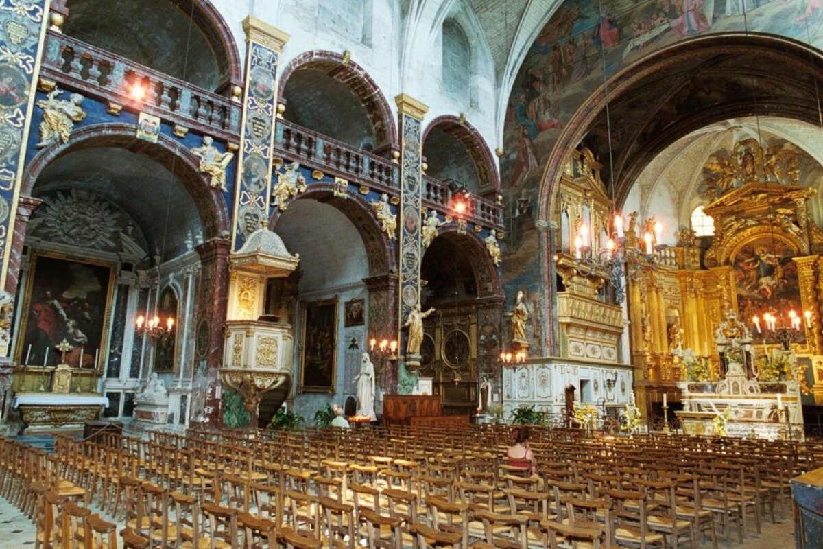 the interior of a lavish church with lots of wooden chairs