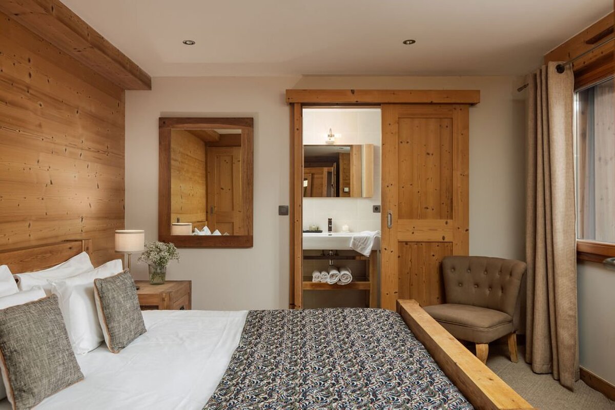 A bedroom with a sliding door leading to a bathroom