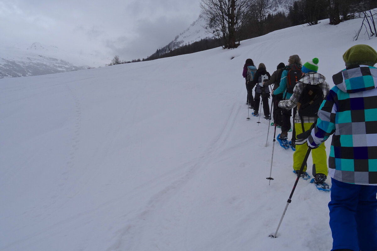 a line of people walking up a snowy hill