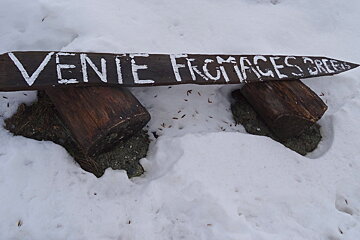 a sign pointing to a cheese farm