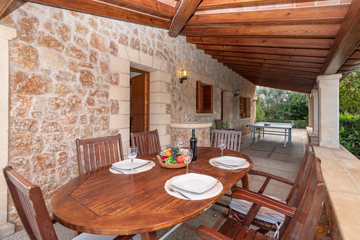 A wooden table with plates and wine glasses on it