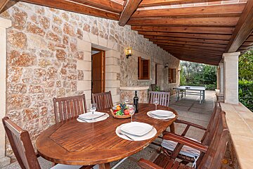 A wooden table with plates and wine glasses on it