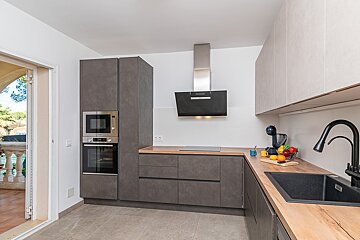 A kitchen with stainless steel appliances and wooden counter tops