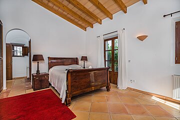 A bedroom with a wooden bed and two lamps