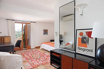 A bedroom with a poster of negroni on the dresser