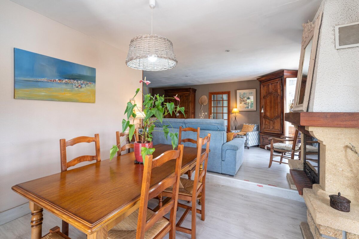 A living room with a table and chairs and a painting on the wall