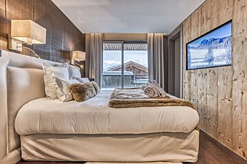 A bedroom with a large bed and a flat screen tv