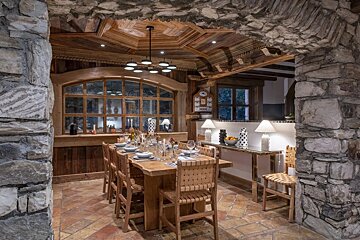 A dining room with a wooden table and chairs