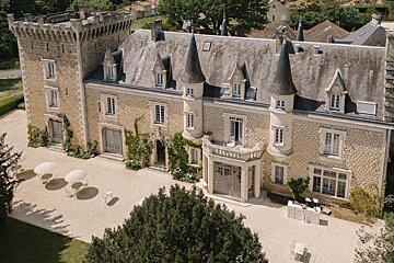 An aerial view of a castle with umbrellas and chairs in front of it