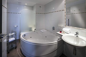 A bathroom with a jacuzzi tub and a sink