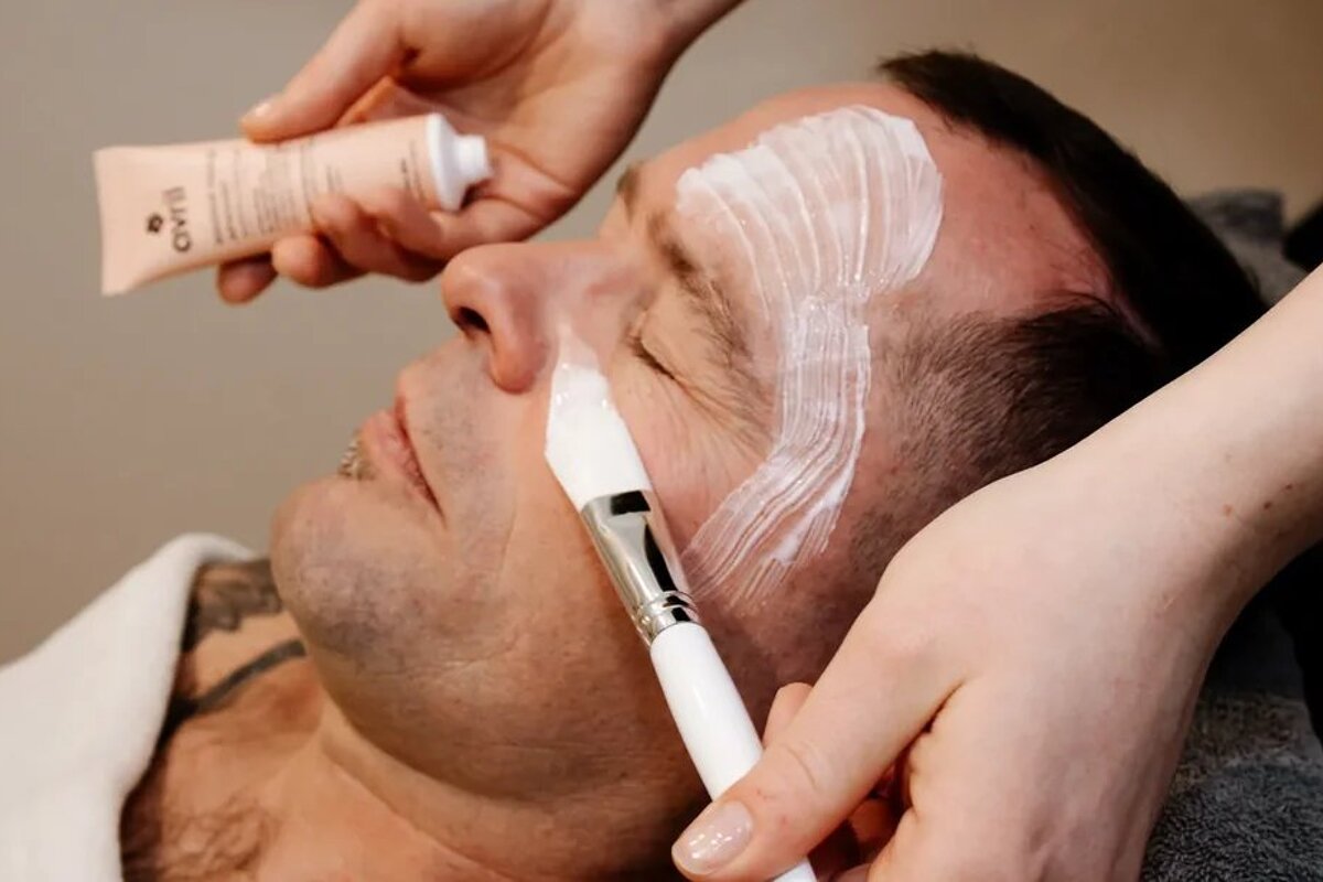 A man is getting a facial treatment from avril