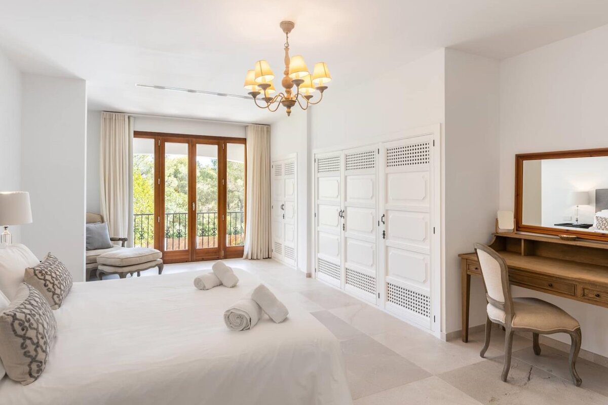 A bedroom with a large bed and a desk