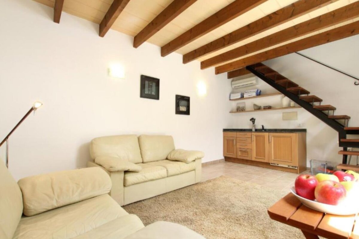 A living room with a couch and a bowl of apples on a table