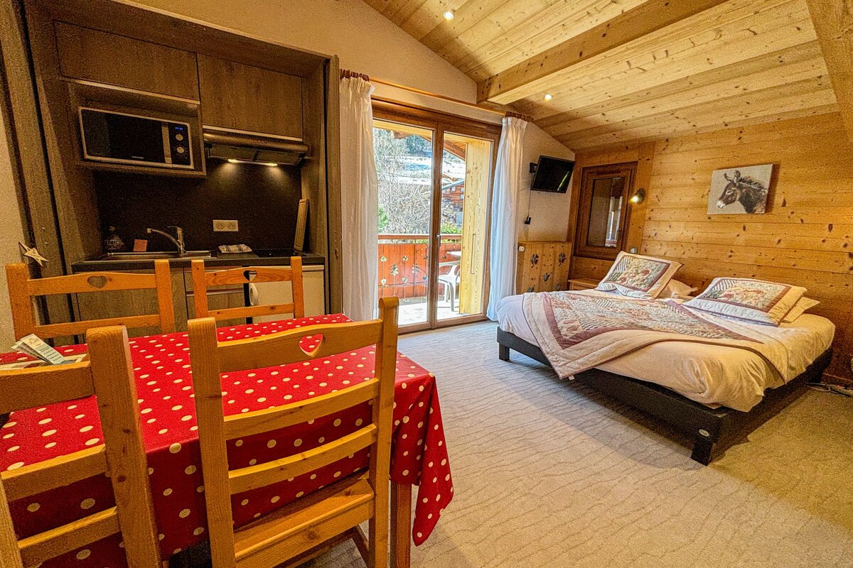 A bedroom with a table and chairs and a bed