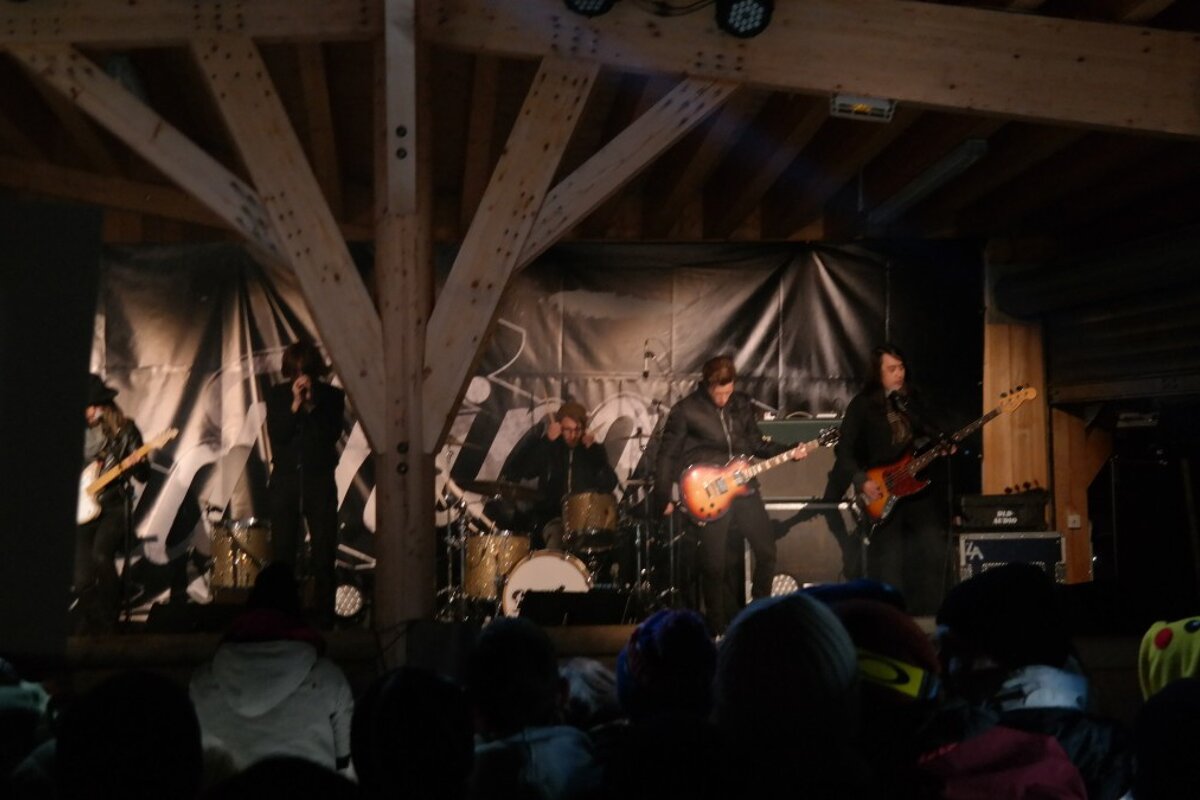 A group of people playing instruments in front of a sign that says ' nocturne ' on it
