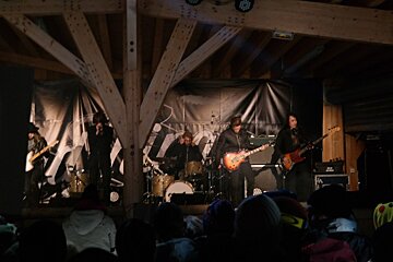 A group of people playing instruments in front of a sign that says ' nocturne ' on it