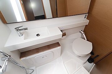A bathroom with a toilet a sink and a mirror