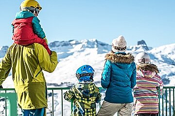 a family looking at the snowy mountains
