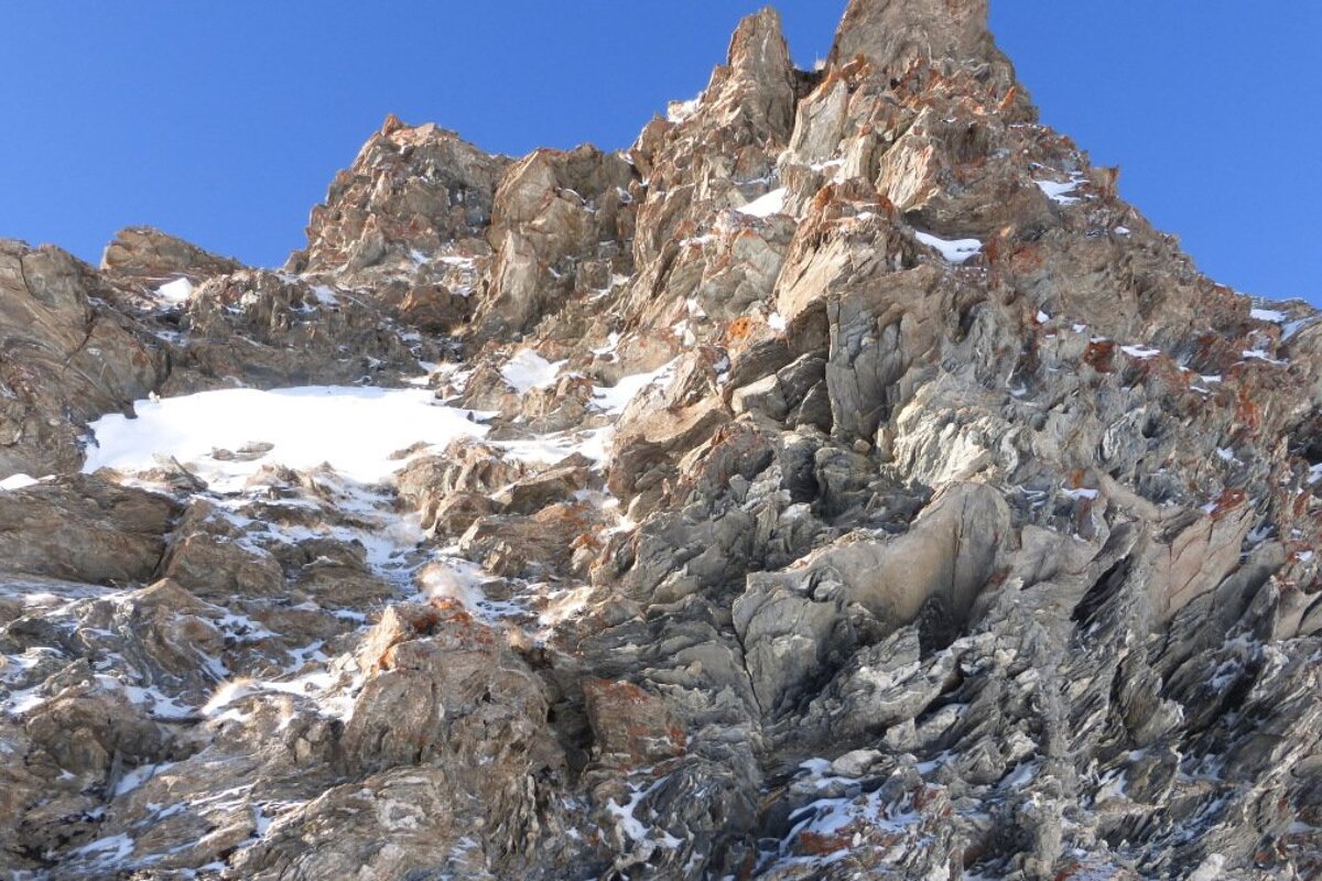 A mountain with a lot of rocks and snow on it