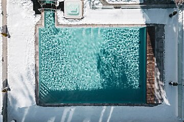An aerial view of a swimming pool covered in snow